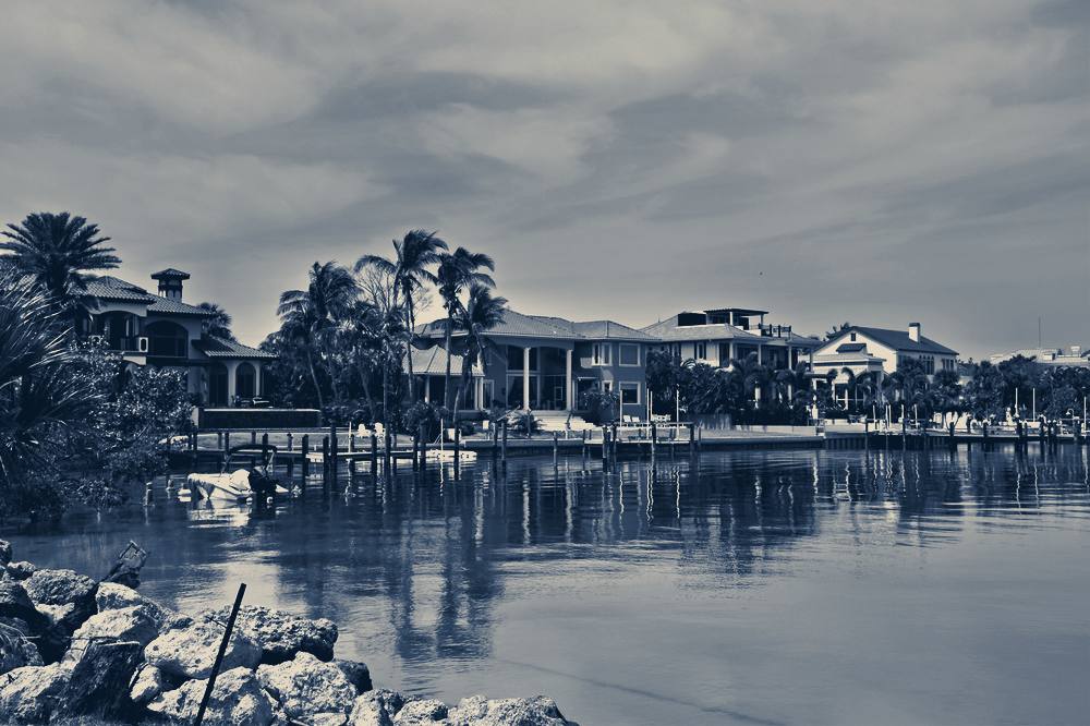 Waterfront houses reflected in calm water, Sarasota, Florida